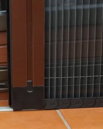 Zaawansowany system łańcuchowy w moskitierze plisowanej Zdjęcie przedstawia zaawansowany system łańcuchowy używany w moskitierze plisowanej. Widoczne są detale mechanizmu, w tym łańcuch i prowadnice, które zapewniają płynne otwieranie i zamykanie moskitiery. System ten jest znany z długotrwałej trwałości i niezawodności, idealnie wpisując się w potrzeby domów w Łodzi.